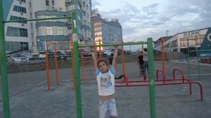 Девочка в 10 лет делает упражнения на турнике