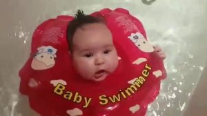 Купание младенца с кругом на шее