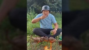 Китаец жарит мясо. Пьёт и закусывает огурцом.