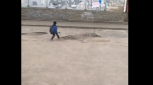 Мальчик из Омска засыпает ямы грязью и щебёнкой