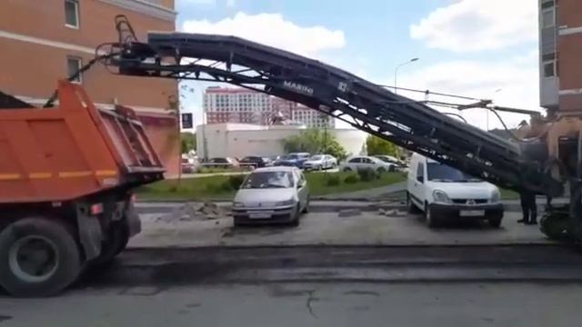 Дорожные работы. Дорожная фреза срезает верхний старый слой асфальта и засыпает в оранжевый самосва смотреть онлайн