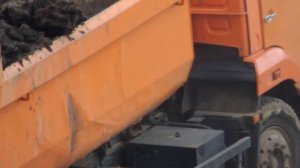 Камаз 65115 самосвал выгружается около стройки