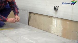 Установка нижнего ряда плитки на стене.