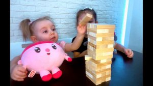 Ева и Алина играют в настольную игру " Падающая башня" (Дженго)