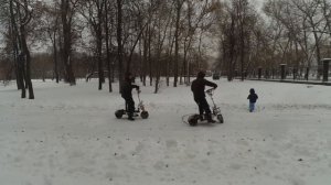 По снегу на электросамокатах.