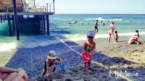 Дети весело играют на море - купают машинки, прыгают на волнах