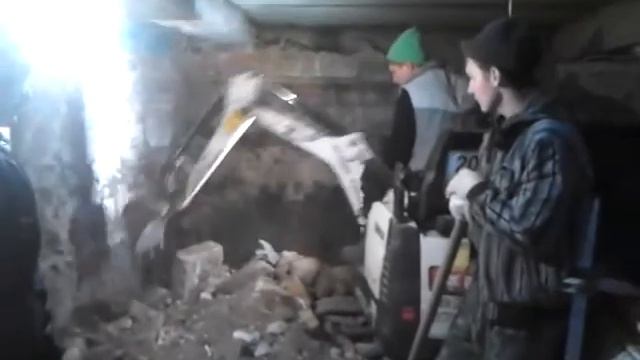 Миниэкскаватор копает в подвале
