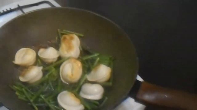 Жареные пельмени со стрелками чеснока.