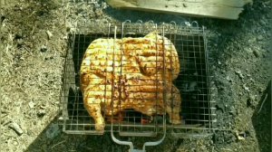 Курица целиком на мангале на решетке