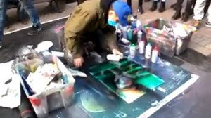 Мужчина рисует картины баллончиком.