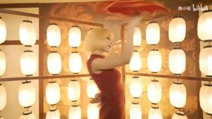 Девушка танцует в платье, в черных чулках и  туфлях на шпильке.