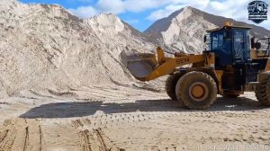 Погрузка белого песка в карьере.