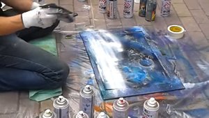 Парень рисует картину при помощи балончиков.