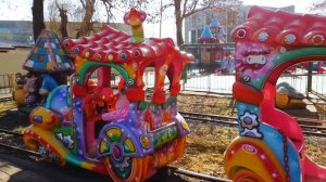 Милана катается в парке на аттракционах