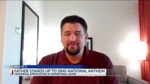 Father stands up to sing national anthem