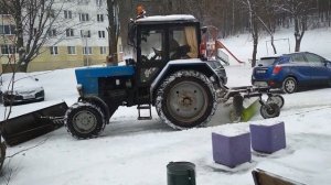 Город завалило снегом. Трактор со щеткой чистит снег на полном газу.