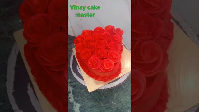 red colour heart shape cake design with full Red roses