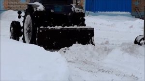 Трактор чистит снег