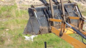 Спецтехника в работе - Экскаватор погрузчик вбивает столбы для забора