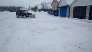 Нива с отвалом чистит снег.