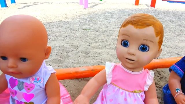 Funny Polina playing with Colored cups and baby dolls on the playground