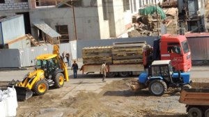 Экскаватор Погрузчик ровняет груз на Манипуляторе Ман, чтобы закрыть Борты.