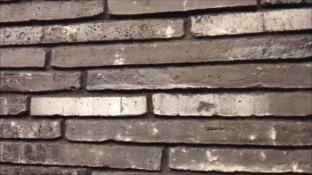 Кладка ригельного кирпича чёрного цвета. Каменщики.