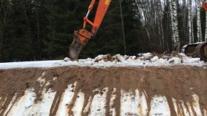 Гусеничный экскаватор Hitachi Zaxis 200 вскрывает мерзлый грунт