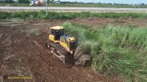 Бульдозер очищает участок от высокой травы.