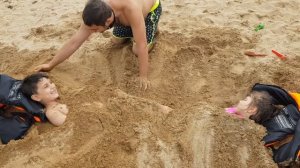 закопали в песок на море только голова торчит