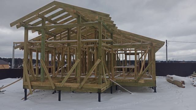 строители возводят каркас дома