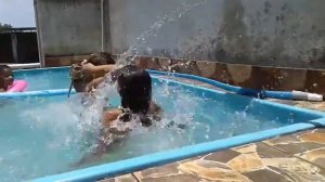 Manu e a prima brincando na piscina.