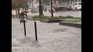 Мужчина сел в воду посреди затопленной ливнем улицы Омска и расслабляется