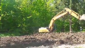 Экскаватор ровняет дорогу на окружной