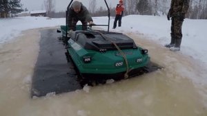 Плавающий мотобуксировщик в проруби