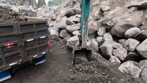 Строительство, экскаваторы двигают большие камни чтобы добраться до песка