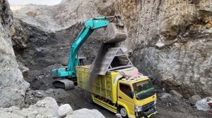 Строительство, экскаватор загружает грузовик