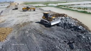 Строительство насыпной дороги на озере. В работе самосвалы и бульдозер. Релакс видео