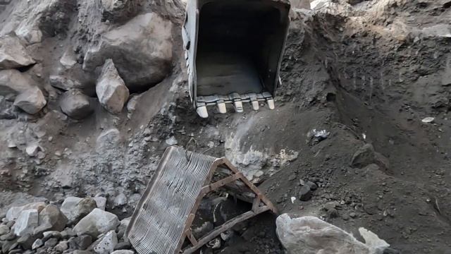 Строительство, экскаватор копает чёрный песок