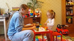 Настя и Оля лепят цветочек из пластилина.