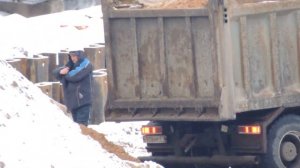 Самосвал - Выгрузка песка зимой на стройке.