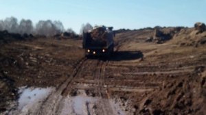 груженная скания пытается заехать в крутую гору по грязи. грязь. грузовики. самосвалы.