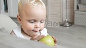 Sweet Blond-haired Baby Eating Green Apple | Stock Footage - Envato elements