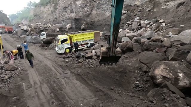 Строительство, экскаватор продолжает копать чёрный песок