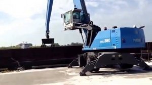 Перегружатель Fuchs MHL380 - разгрузка судна в порту.