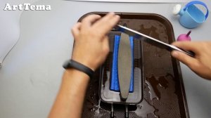 Sharpening a kitchen knife with an old and crooked wet stone.