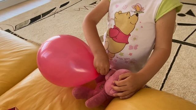 Маша и розовый медведь надувают шары.