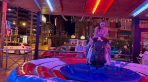 Girl in a pink T-shirt Riding on a Bull in Benidorm | Bull Riding 4K