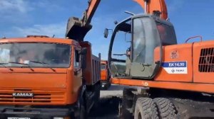 Погрузка самосвала экскаватором. Проведение ремонтных работ автомобильных дорог