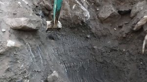 Строительство, экскаватор копает сверхтвёрдый чёрный песок